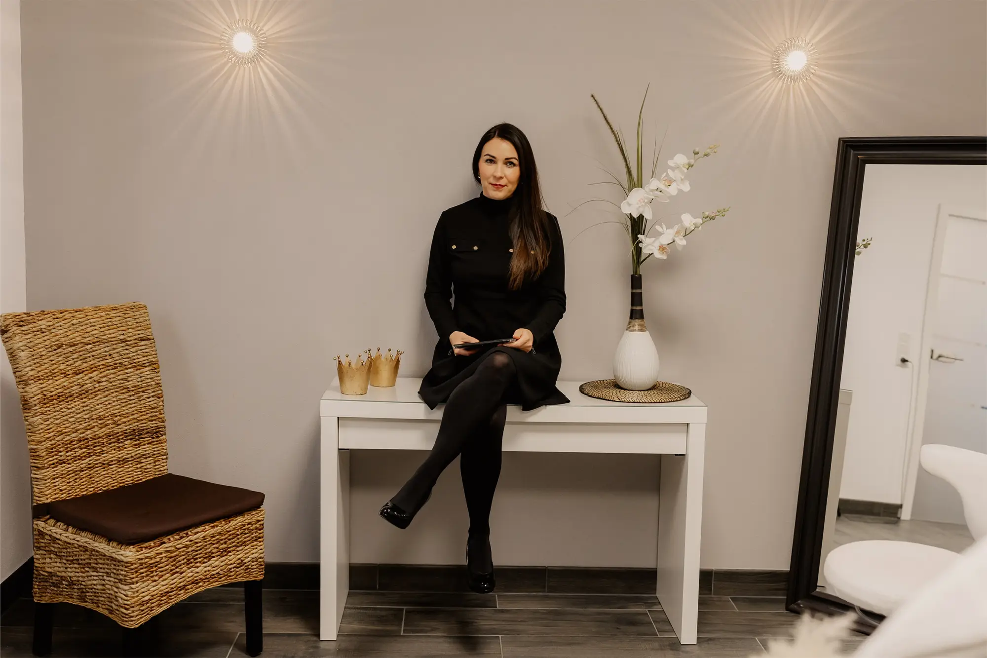Anna Simon im Studio von Beauty in Perfection® sitzt elegant auf einer Konsole im Empfangsbereich
